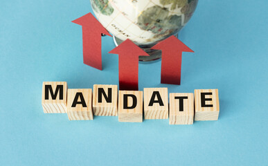 Mandate is written in wooden blocks on a blue background