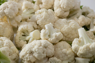 Fresh and raw cauliflower on the white plate.  The cauliflower  -  vegetable is cut into pieces on...