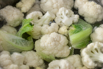 Fresh cauliflower is boiled in a water. The vegetable is divided into florets and boiled