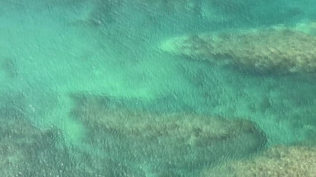 Flowing clear emerald green sea water, aerial view.