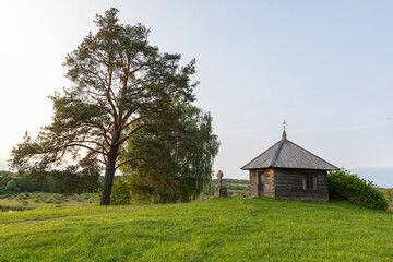 A picturesque ancient wooden chapel surrounded by lush greenery