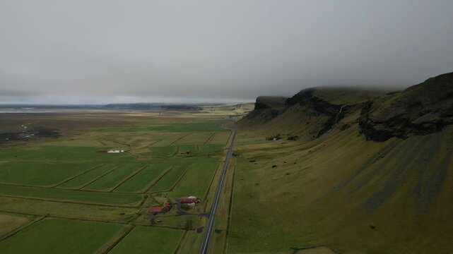 Moody Iceland Aerial. Green Plains and Dark Mountains in Mist