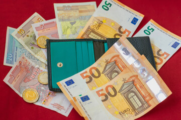 Wallet with euro and Bulgarian lev banknotes and coins on red background. Bulgaria, transition to Euro, finance and budgeting. Concept of personal money, savings, financial international spending