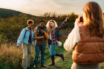 Smiling group of diverse hikers posing for a photo on a trail.