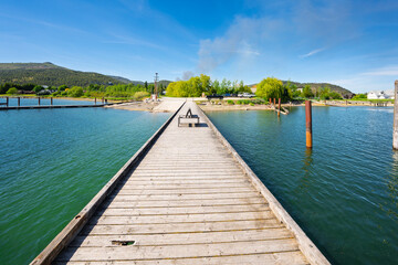 Obraz premium A wooden dock juts out into the Pend Oreille River near the Riley Creek Recreation Area at the rural small town of Laclede, Idaho.
