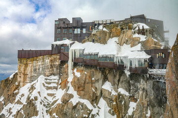 View of Aiguille du Midi mountain station in the Mont Blanc massif in the French Alps. Summit tourist station in foreground. Alps France Europe.	