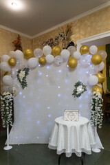 Elegant Wedding Backdrop Decor with White Balloons, Gold Accents and Floral Arrangements for Reception, Table and Guest Book Station.