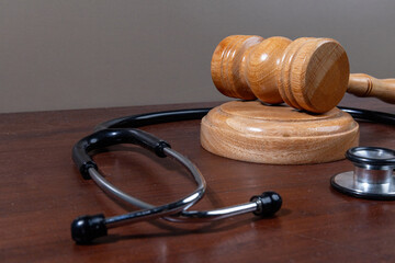 A powerful visual of a gavel and stethoscope placed together on a desk symbolizes the legal...
