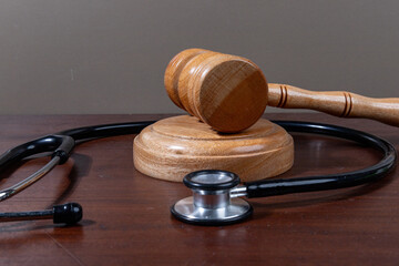 A powerful visual of a gavel and stethoscope placed together on a desk symbolizes the legal scrutiny over medical practices.