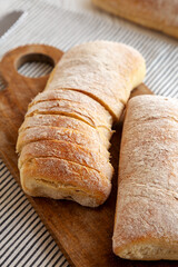 Homemade Ciabatta Bread on a wooden board, side view.