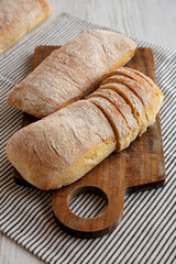 Homemade Ciabatta Bread on a wooden board, side view.