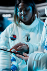 Close up of female astronaut scientist tracking star and asteroids patterns using tablet, recording...