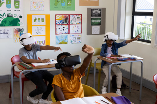 In school, diverse students using virtual reality headsets for interactive learning experience