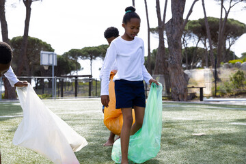 Diverse students participating in sack race outdoors, enjoying playful school activity