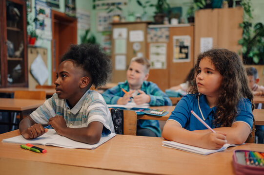 Elementary school students listening to teacher in classroom