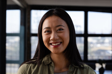 In office, Asian woman smiling confidently, exuding positivity and assurance, copy space