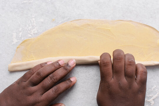 Overhead view of rolled paratha dough on a marble countertop, top view of flaky flatbread dough, process of making paratha