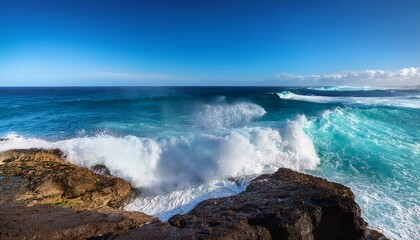Fototapeta premium turquoise ocean waves crashing against rocky shore under sunny sky on a clear day