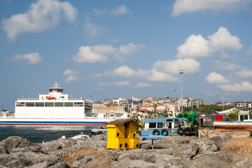 Colorful Yellow Cat House for Stray Cats on Rocky Coastline in Kartal Marina Istanbul Turkey with Boats and Sailboats in Background on Sunny Day