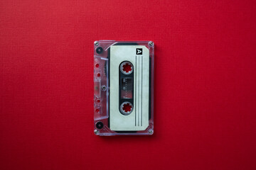 Retro audio cassette for tape recorder on red background. Symbol of 80s and 90s period. Selective...