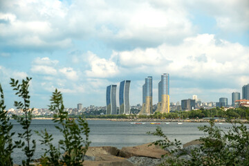 Modern Waterfront Promenade and Park in Istanbul Turkey with Walking Path Along Coastline and Skyscrapers Skyline Under Cloudy Sky on Sunny Day