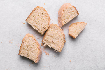 Overhead view of sliced homemade artisan bread on marble countertop, top view of cross-section of sourdough artisan bread on white background