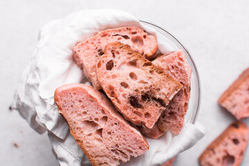 Overhead view of strawberry and chocolate sourdough, top view of pink and chocolate artisan bread on a white background, open crumb artisan bread on white background