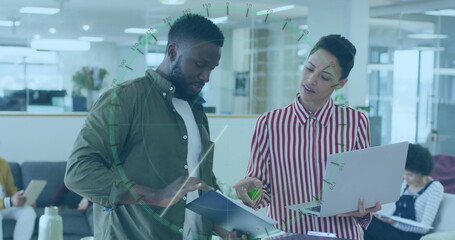 Reviewing professionals pointing at open document folder in modern office, with laptop