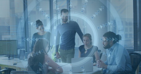 Five colleagues in business attire collaborating in office conference room, with laptop and overlay