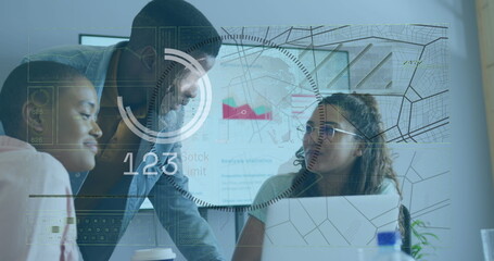 Analyzing data three coworkers leaning over office table, using laptop and floating charts and map