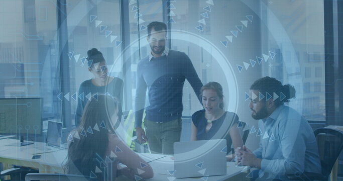 Five colleagues in business attire collaborating in office conference room, with laptop and overlay