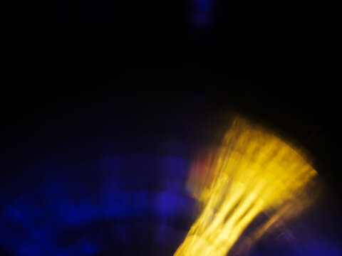 Abstract bokeh scene. Golden and blue glowing light leaks on black color background for design. Light effect.
