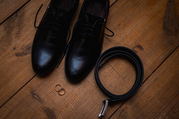 Elegant wedding details flatlay on rustic wooden background. Groom accessories - black leather...
