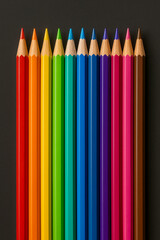American School Colored Pencils in Rainbow Order on Dark Background