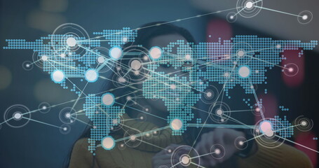 Asian woman in mustard sweater and visor interacting with digital map in lab, with glowing nodes