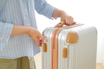 旅行バッグを持つシニア女性の手元
