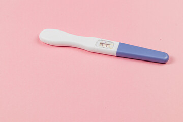 Positive pregnancy test on pink background showing results