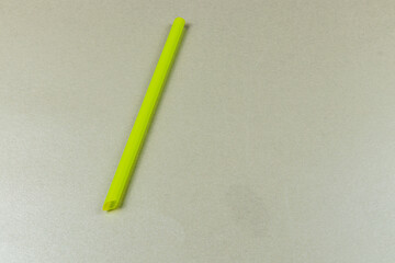 Bright yellow straw placed on a light surface in a kitchen