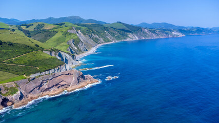 Obraz premium Breathtaking zumaia flysch cliffs and coastline meeting deep blue ocean in basque country