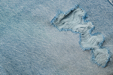 Denim fabric with a visible tear and frayed edges