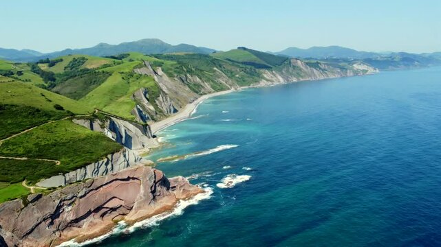 Breathtaking aerial perspective of zumaia's flysch coastline, showcasing its unique geological formations and vibrant summer hues