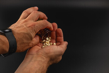 Hands pouring pills from a bottle into an open palm
