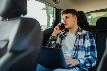 Young caucasian man student traveling on backseat and talking on phone