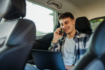 Young caucasian man student traveling on backseat and talking on phone