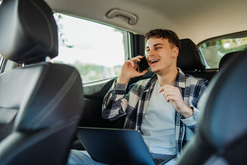 Young caucasian man student traveling on backseat and talking on phone