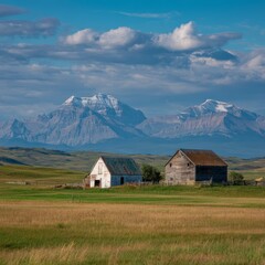 Obraz premium Rural landscape featuring two old buildings set against majestic mountains under a cloudy sky. The scene showcases the beauty of countryside architecture and the serenity of nature.