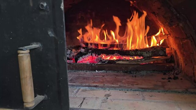 Traditional wood-fired oven with intense flames ready for baking pizzas, pandebonos, and arepas de choclo, rustic cooking with natural firewood heat, glowing embers and authentic culinary ambiance