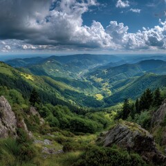 Naklejka premium A majestic mountain range under a cloudy sky. The lush green landscape is vast and beautiful