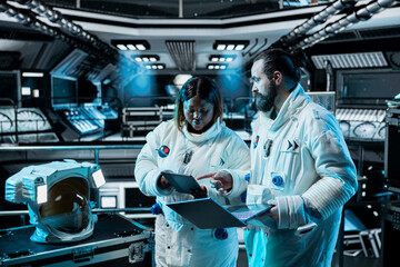 Astronauts monitoring life support systems, conducting safety checks during long distance space travel. Starship colleagues verifying navigation coordinates during cosmic journey