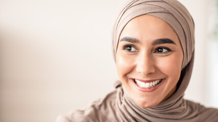 Closeup portrait of cheerful muslim lady in stylish headscarf looking at copy space, panorama....